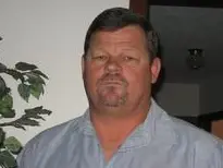 A man in blue shirt and black hair.